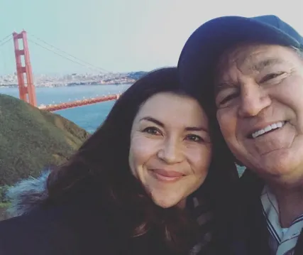 Shauna, founder of tendercare, and her dad Mike smiling in front of the Golden Gate Bridge